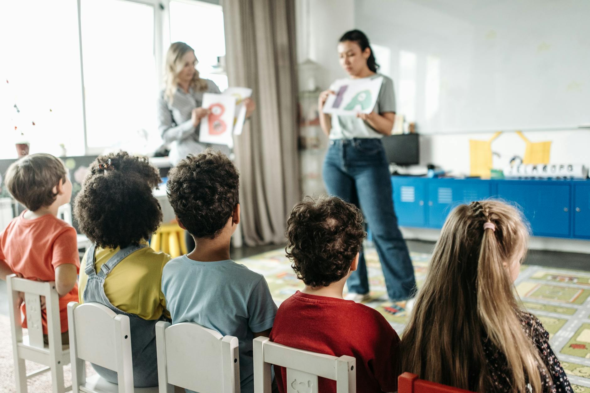 children sitting on white chairs